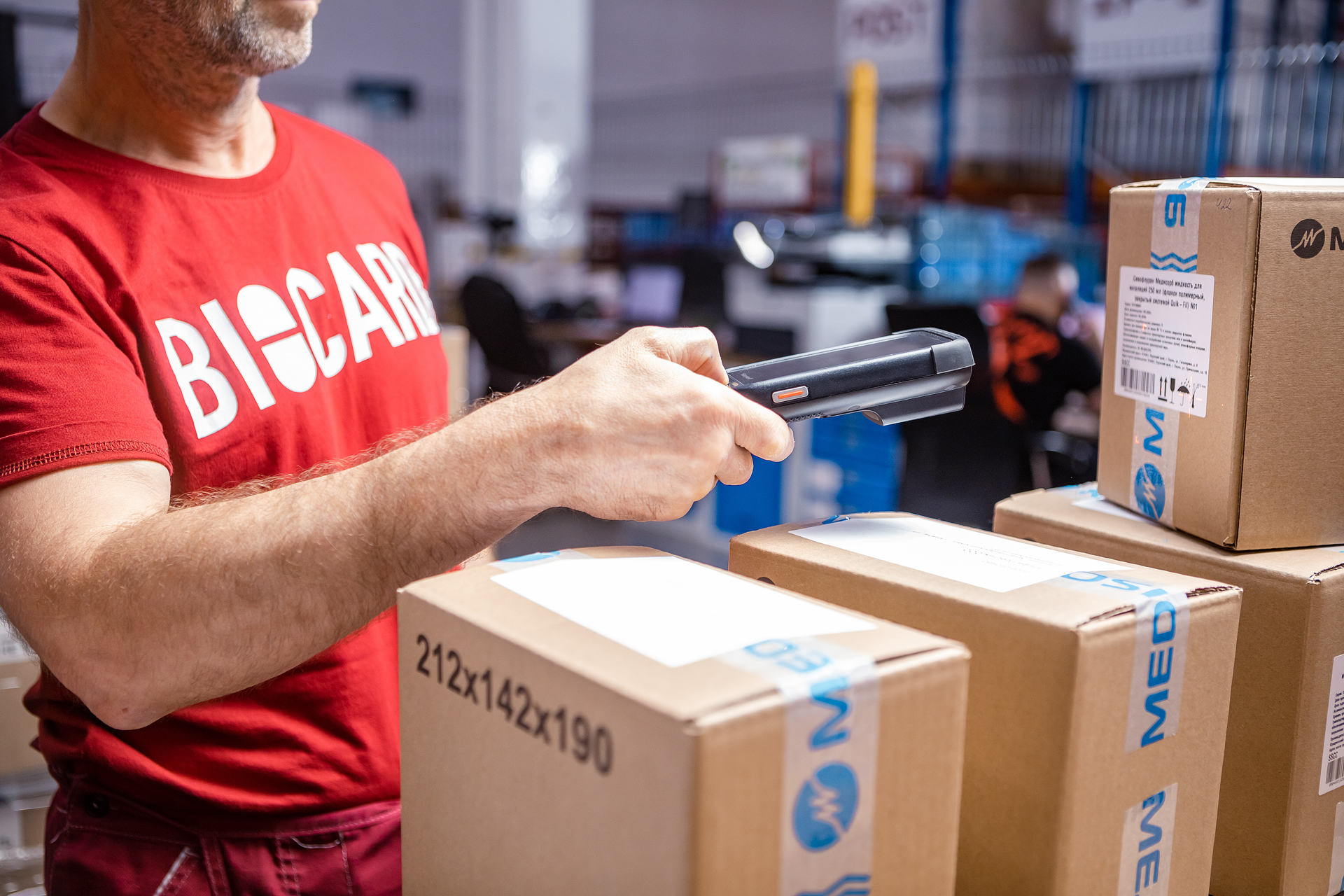 Кладовщик Biocard сканирует маркировку на коробке для перевозки медицинских грузов с температурным режимом по РФ, миру.